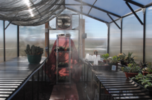 Aluminum greenhouse kit with fan and climate controls.