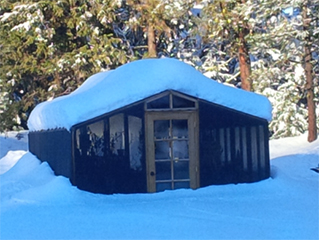 Redwood greenhouse kit in the snow.