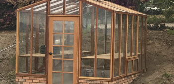redwood greenhouse with brick base